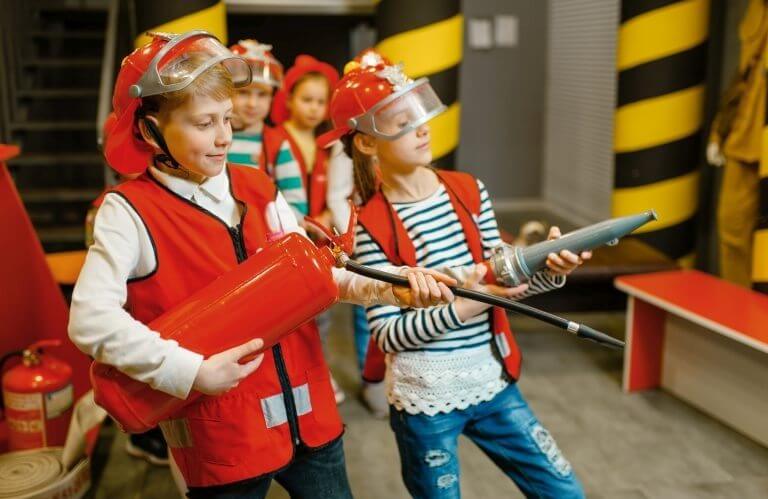 Children playing with hose and extinguisher