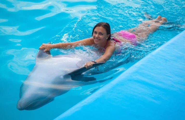 Woman swimming with dolphin in Dubai Dolphinarium